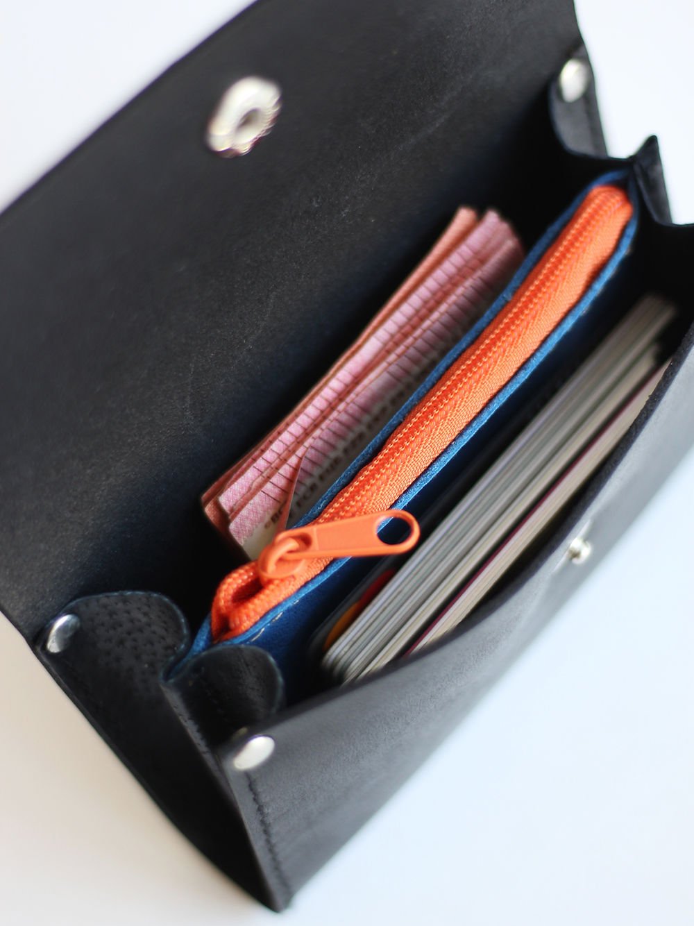1. Open black FRIDAY Wallet by TOKS VISOKS showing spacious interior with cash, cards, and orange zippered coin pocket