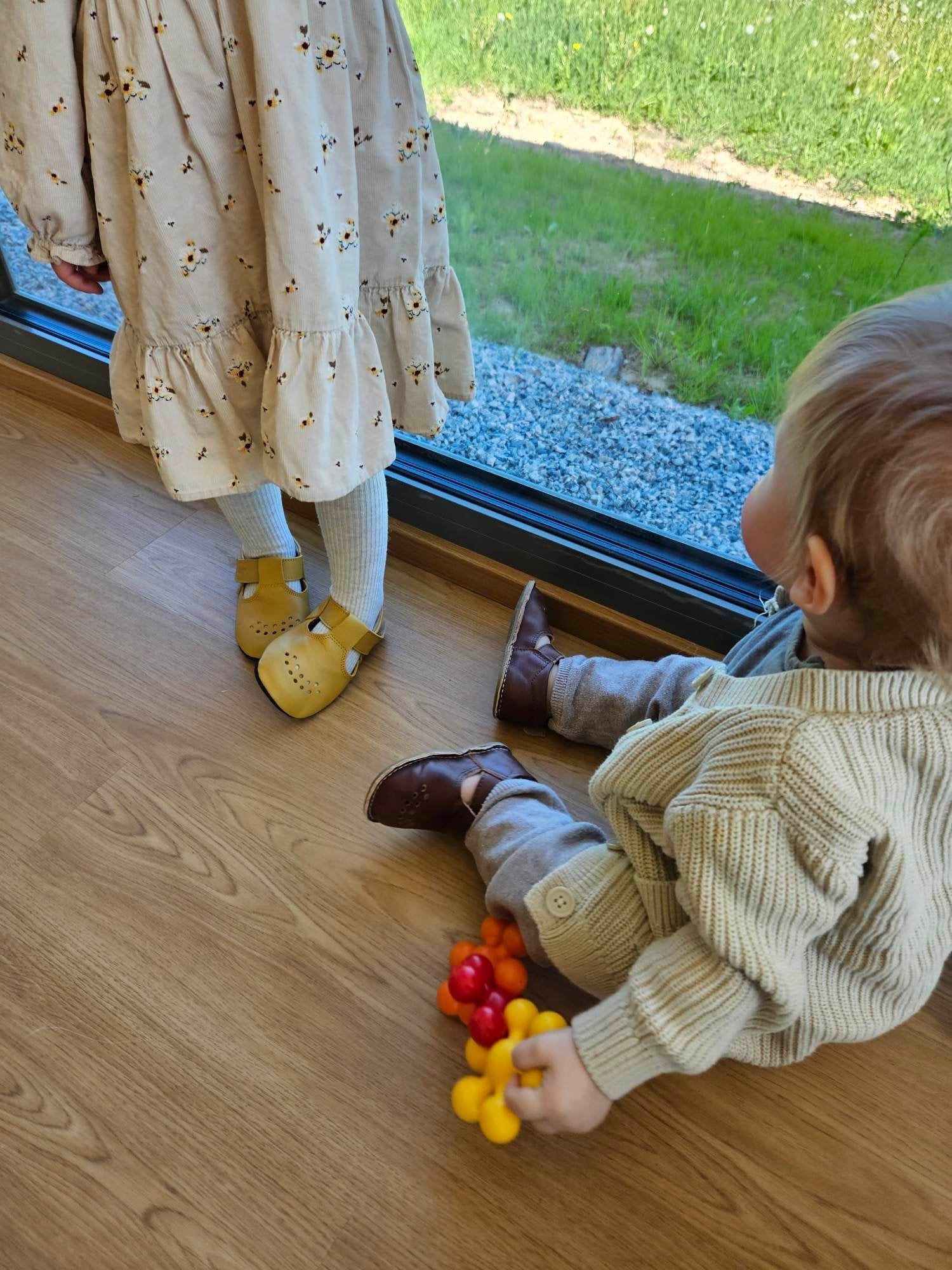 1. Kids wearing Omaking yellow Mutsu slippers, showcasing comfort and style for first steps