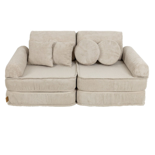 1. Children's modular sofa in aesthetic ecru with ribbed texture, featuring two back cushions and two round pillows, shown in a studio setting