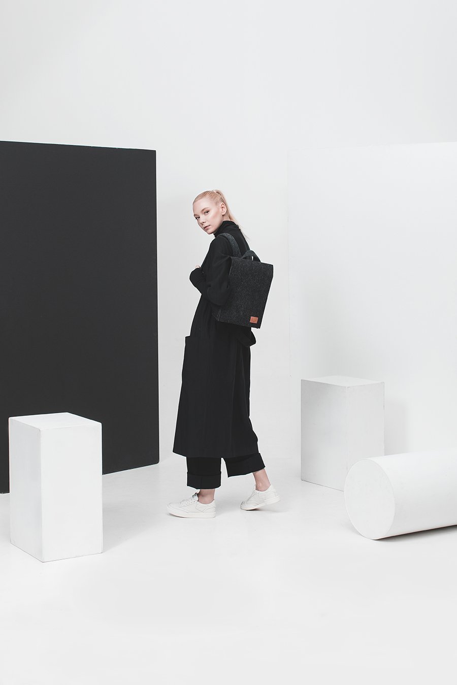 1. Woman wearing Nordhale Lund Mini Backpack in black, styled in a minimalist studio setting