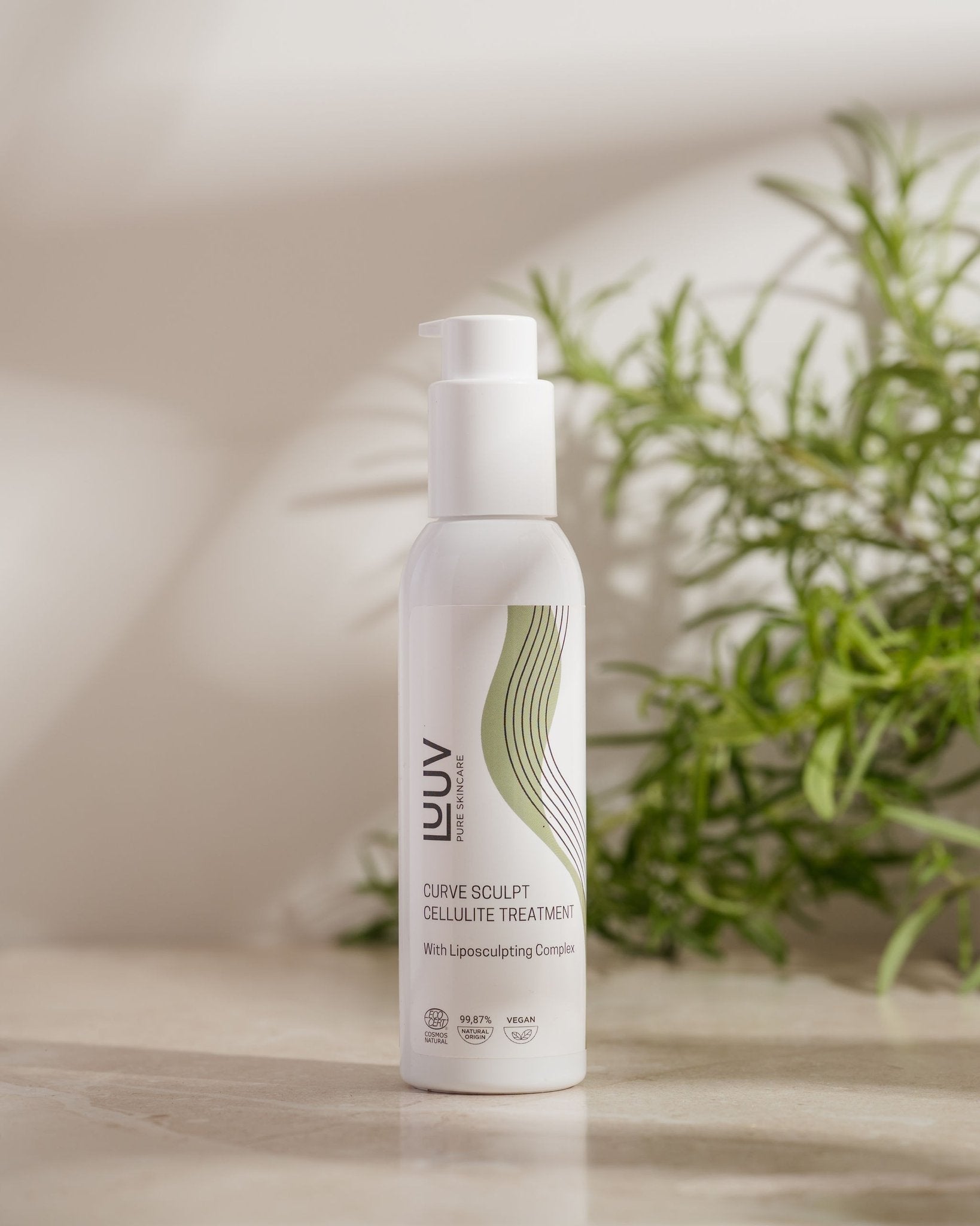 1. LUUV Cellulite Treatment COSMOS bottle on a natural stone surface with green plant in background