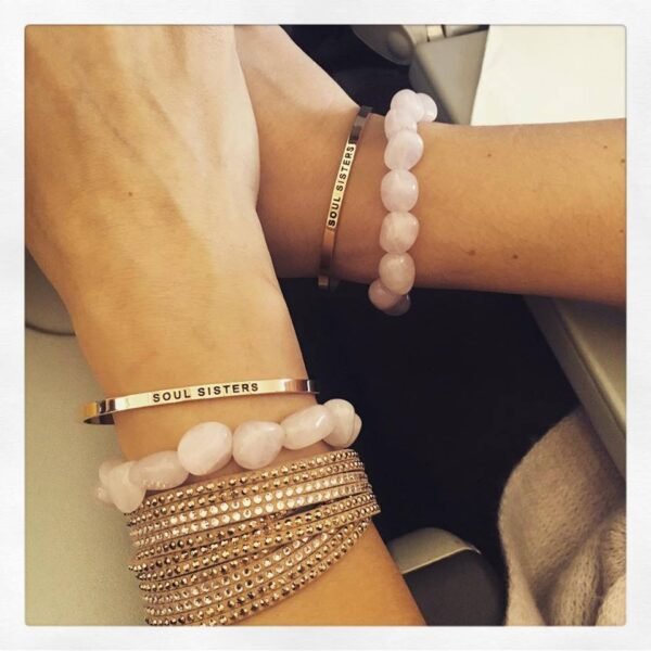 1. Women's Soul Sisters bracelet by Olla worn with other bracelets, showcasing engraved message in lifestyle setting