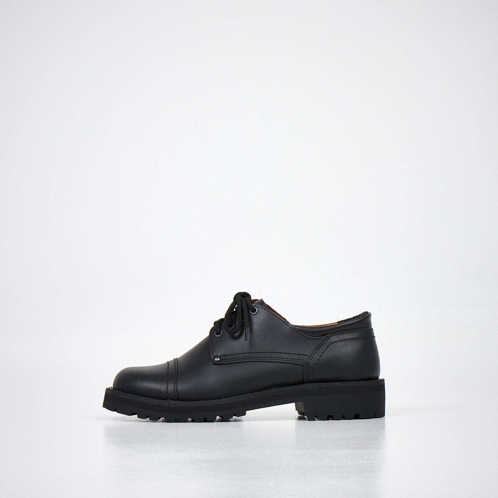 1. Unisex AIPI handmade leather shoes in black, side view showcasing durable stitched-through soles and rubber outsole, studio setting