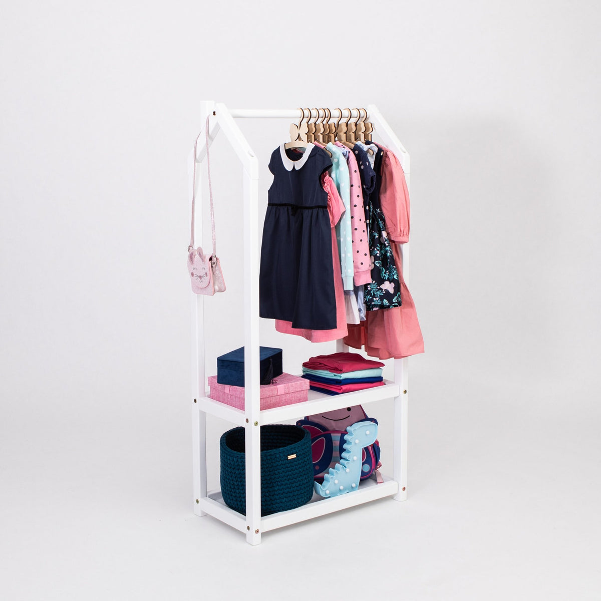 1. White house-shaped clothing rack with children's clothes and storage baskets on a white background