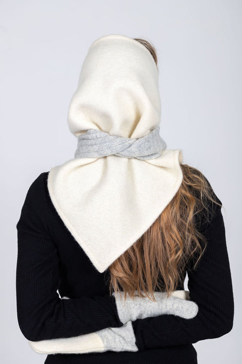 4. Back view of women's HERTTA wool triangle shawl in white and lightest grey, styled as a hood, studio setting