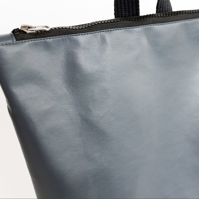 6. Close-up of zipper and top section of Muni grey faux leather backpack