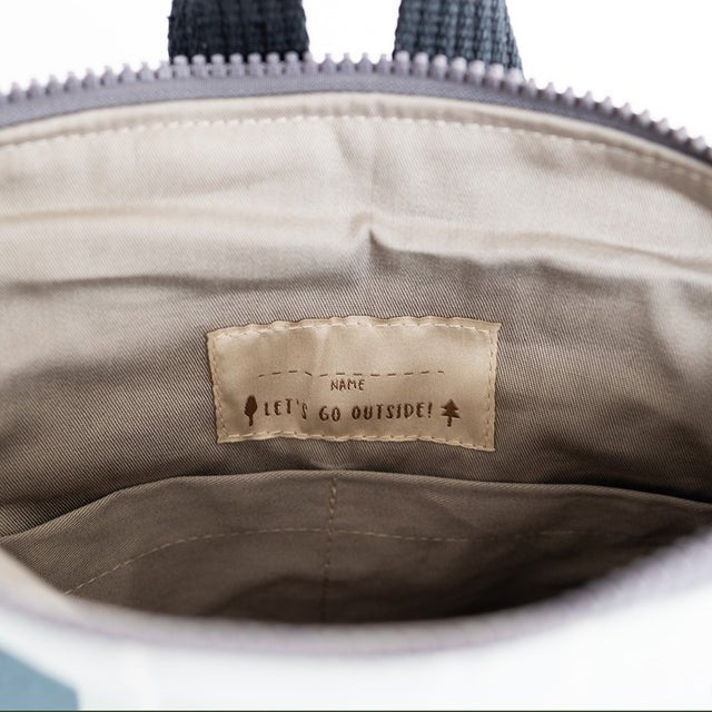 5. Interior of Muni SKY backpack showing cotton lining and 'Let's Go Outside!' label