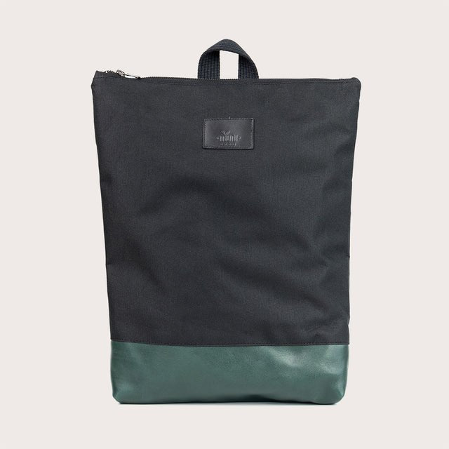 9. Studio image of Muni waterproof backpack with green leather bottom, showcasing minimalist design
