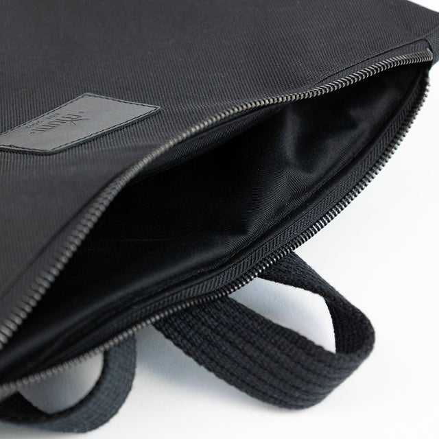 7. Close-up of Muni waterproof backpack's interior, showing black fabric lining and zipper detail