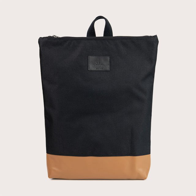 6. Studio shot of Muni waterproof backpack with tan leather bottom, emphasizing minimalist design