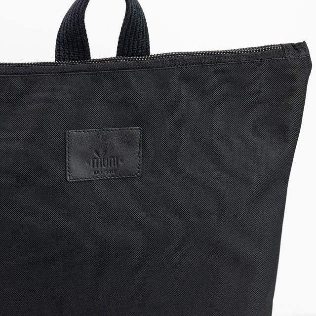 9. Close-up of Muni waterproof backpack's top section, highlighting brand logo and zipper