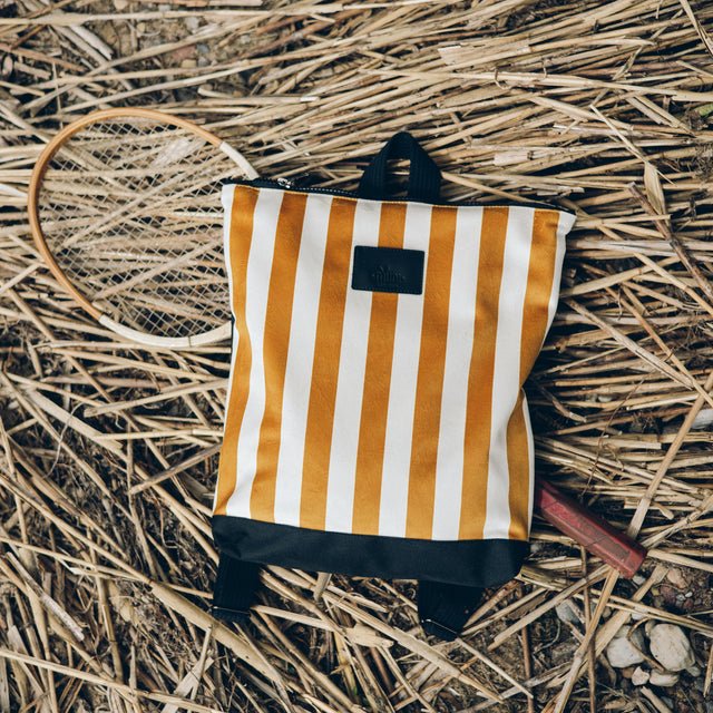 4. Muni striped mustard and white backpack on straw with a badminton racket