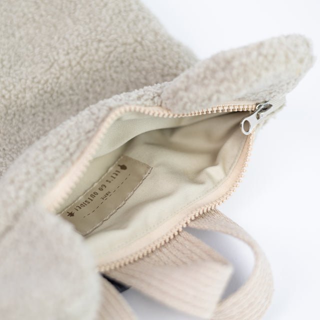 9. Close-up of Muni beige teddy backpack's interior, showing zipper and lining