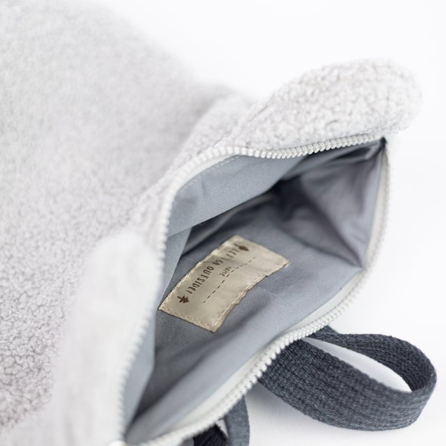 8. Interior view of Muni grey teddy backpack, showing zipper closure and inside slip pockets