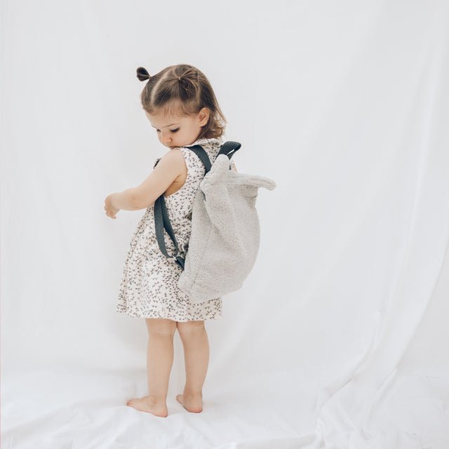 3. Young girl wearing Muni grey teddy backpack, showing adjustable shoulder straps and comfortable fit