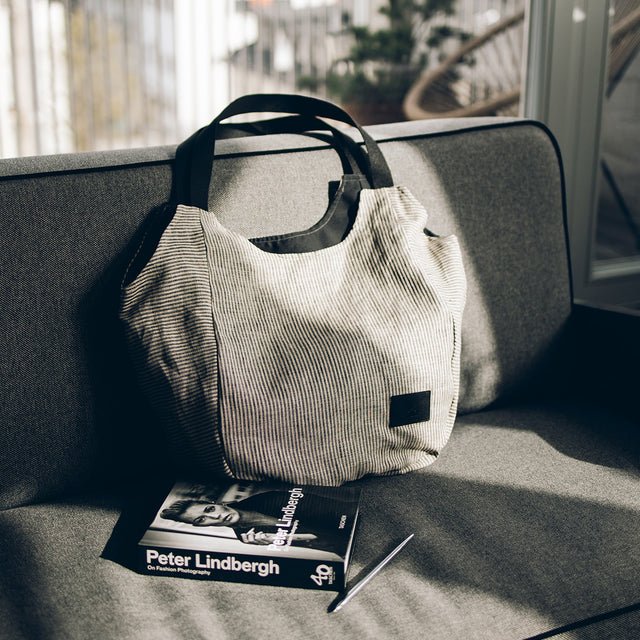 6. Muni striped linen tote bag on a sofa with a book