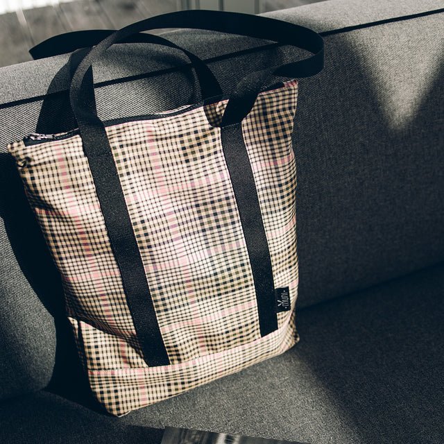 7. Tartan tote bag by Muni on a sofa, emphasizing stylish pattern and everyday usability