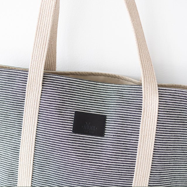 7. Close-up of Muni logo on striped denim tote bag