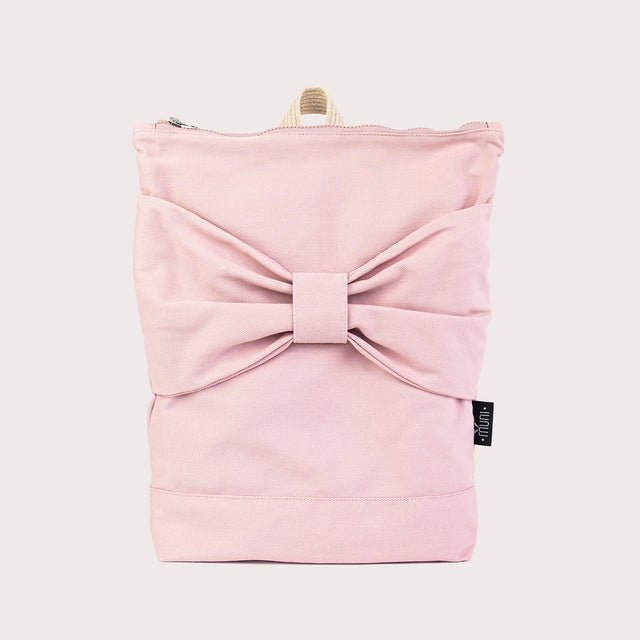 2. Studio image of Muni Pink Bow backpack with large bow on pink denim fabric