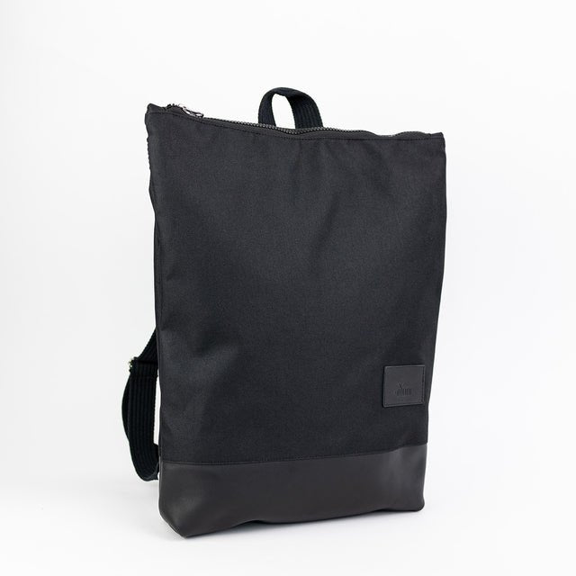 5. Studio image of Muni waterproof backpack with black leather bottom, featuring front view and brand logo