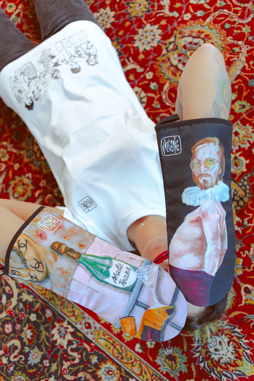 5. Two people lying on a patterned rug holding Katrin Valgemäe oven mitts with pop art designs