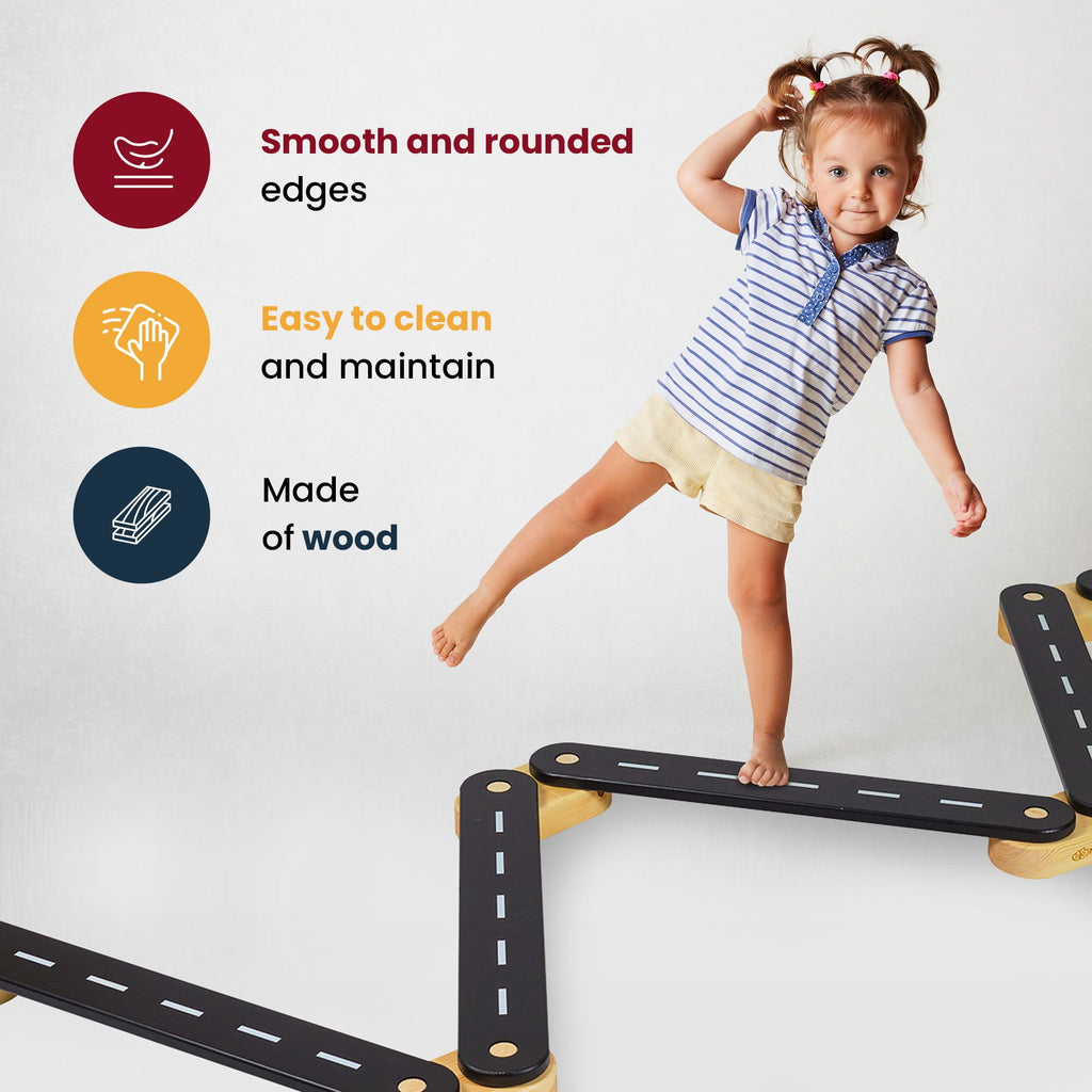 10. Young girl balancing on black wooden beam with road design, highlighting smooth edges and easy maintenance