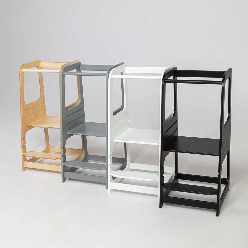8. Four Montessori helper tower step stools in natural, grey, white, and black