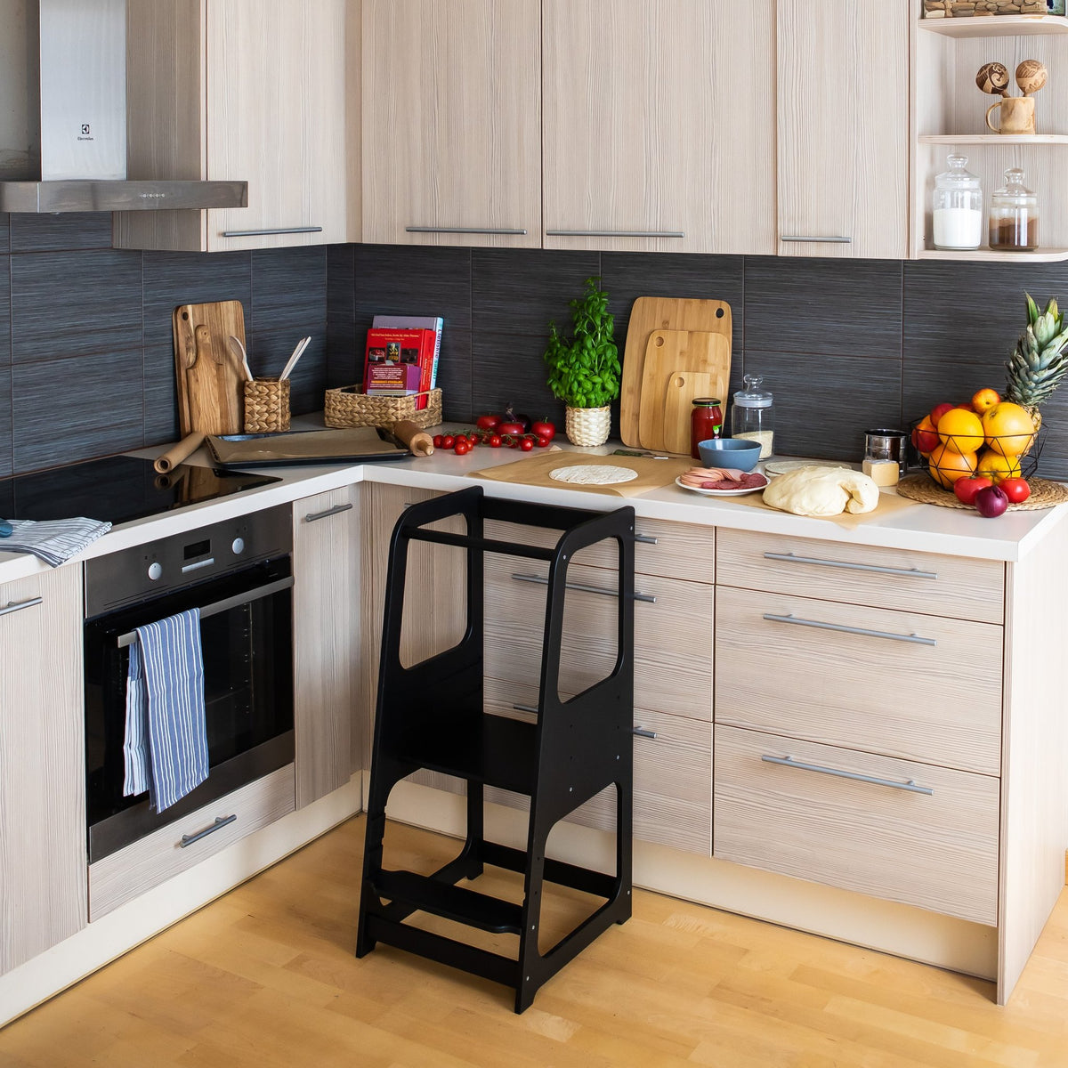 20. Black Montessori helper tower step stool in modern kitchen setting