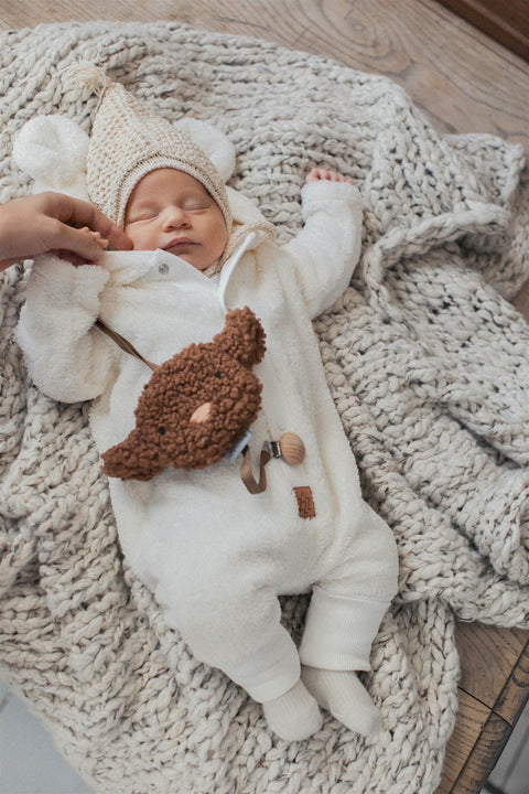 3. Baby lying on knitted blanket in fuzzy ecru jumpsuit with bear ears hood and knit hat