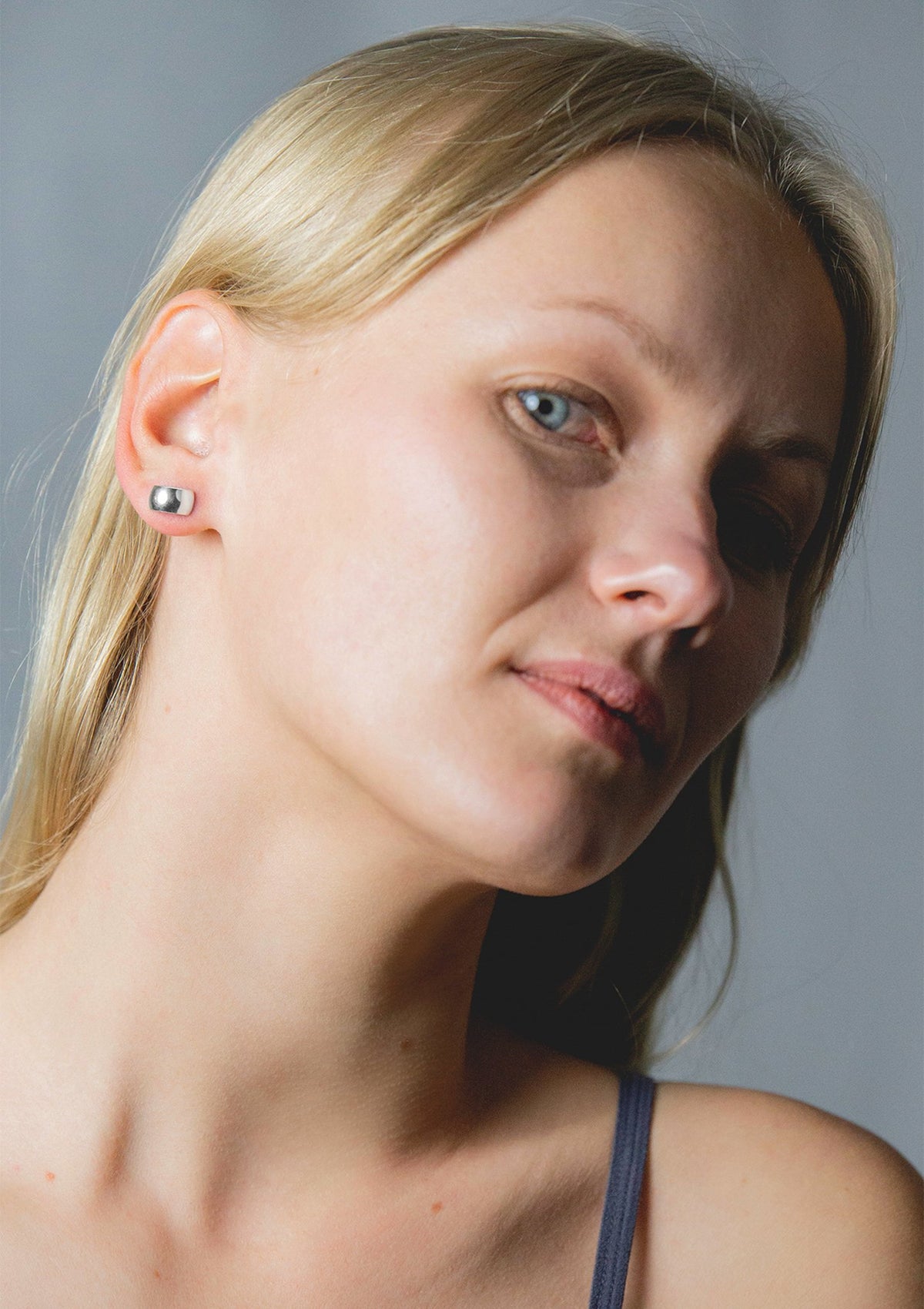 1. Woman wearing Maarja Palu HOLLOW Large Earrings in silver, showcasing minimalist half-circle design