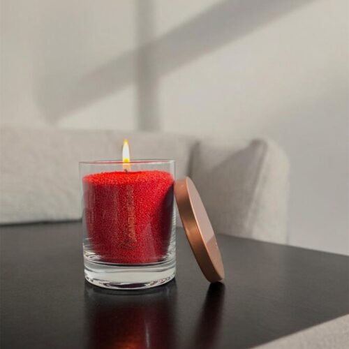 1. Red unscented powder candle by Candledust in glass container with metal lid, burning on a table