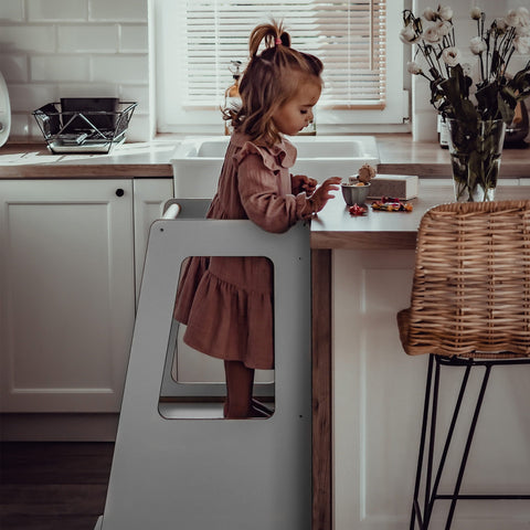 1. Child standing on MeowBaby gray kitchen helper reaching kitchen counter in bright kitchen