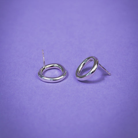 3. Close-up of Maarja Palu Earrings IRREGULAR x1 in polished silver on purple background, highlighting geometric design