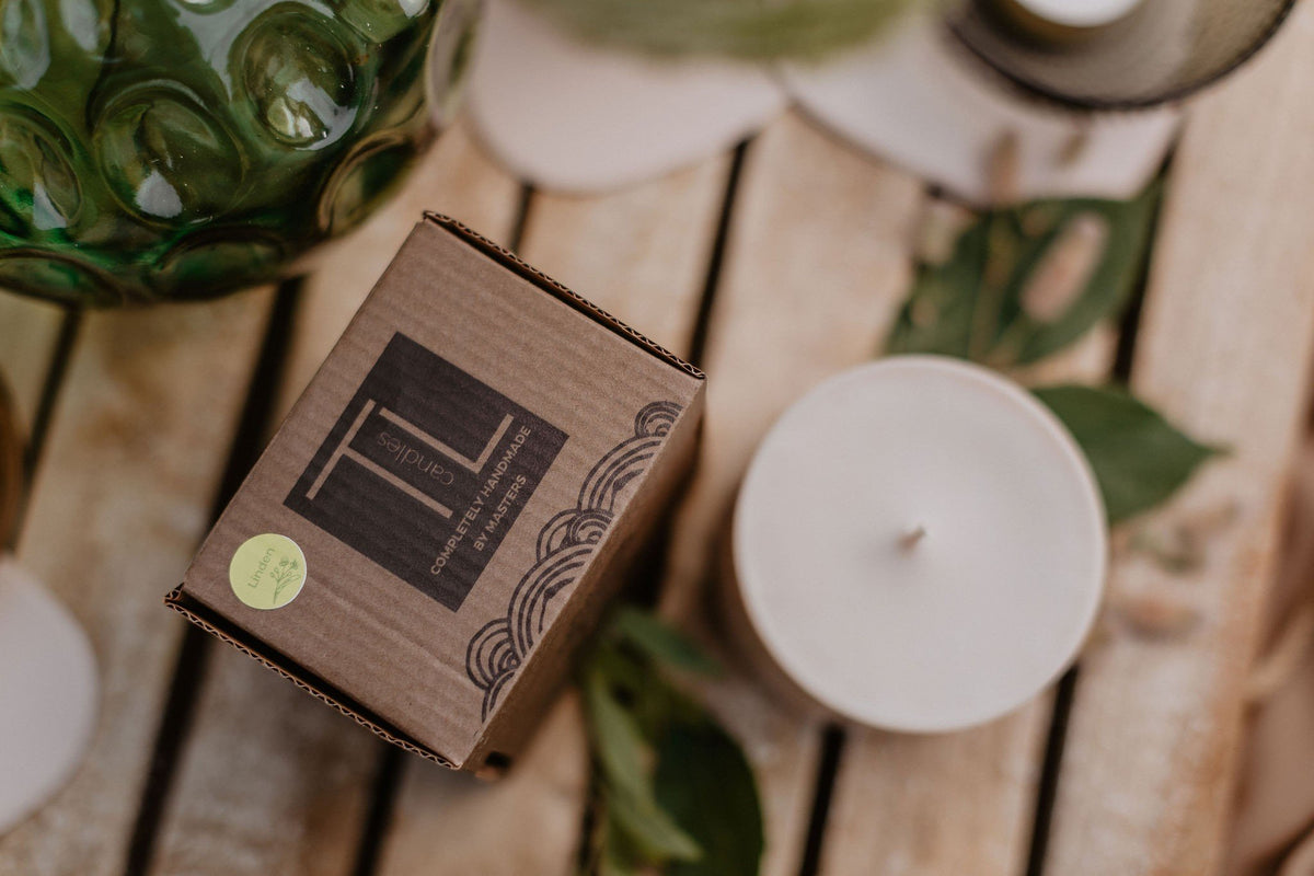 8. TL Candles hand-made soy wax candle with amber pieces, styled on a rustic table with packaging