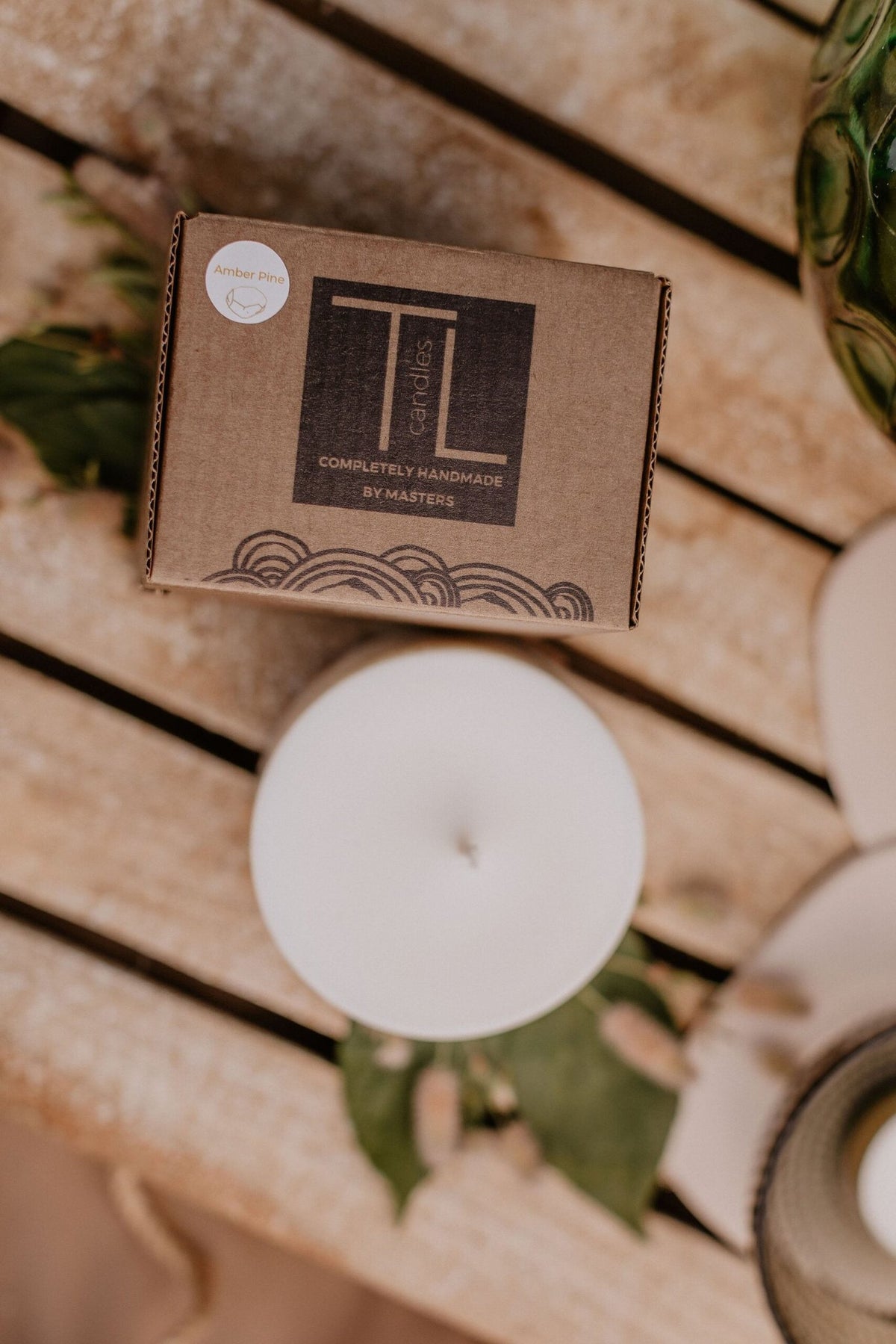10. TL Candles packaging and soy wax candle on wooden surface, emphasizing hand-made quality and pine scent