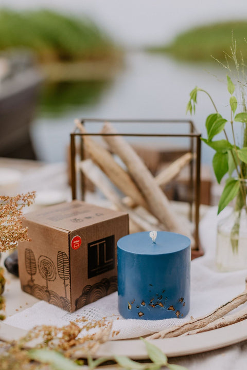 4. TL Candles hand-made blue soy wax candle with amber pieces, shown with branded packaging on a table