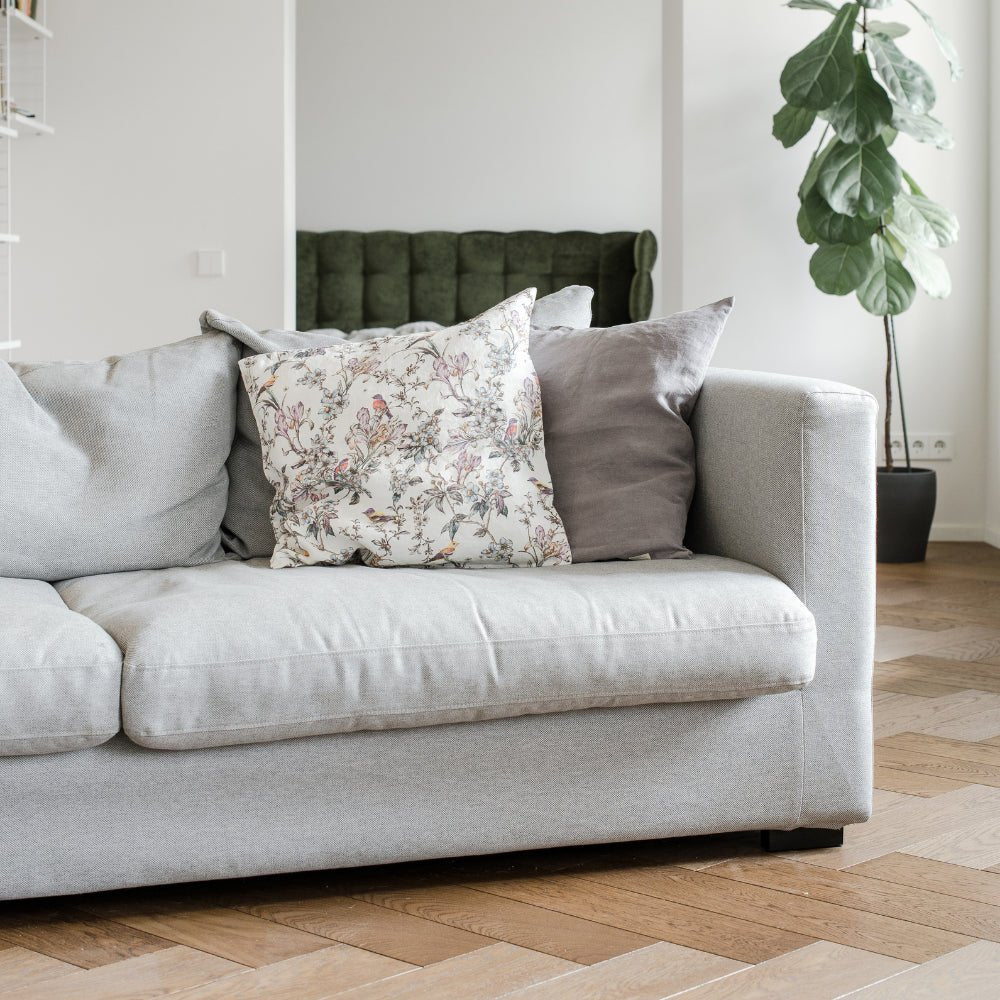 1. Light grey sofa with floral and grey Linen Tales cushion covers in a modern living room setting