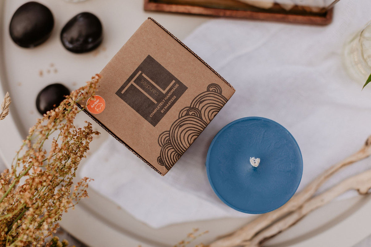 7. TL Candles hand-made blue soy wax candle with branded packaging, displayed on a table with natural decor