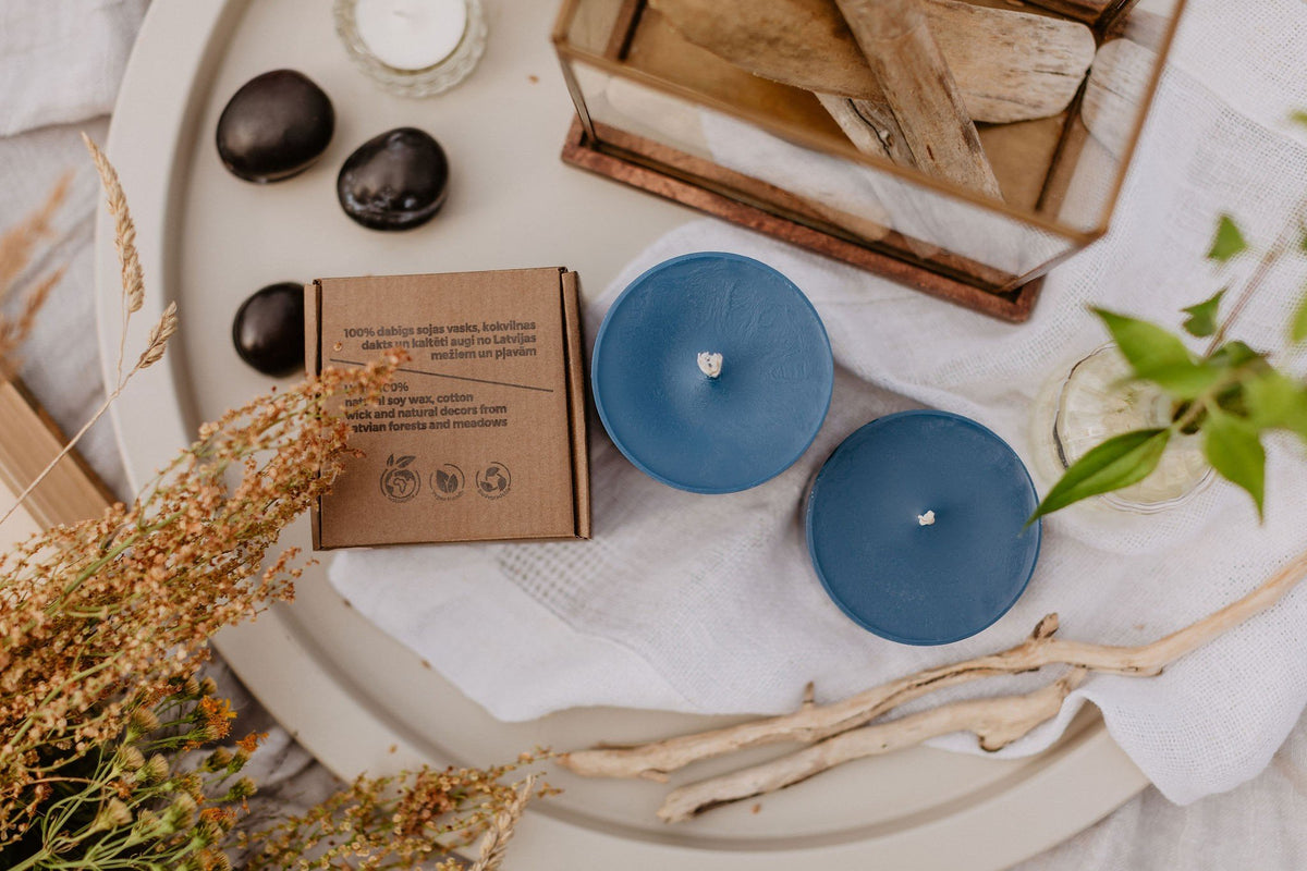 10. TL Candles hand-made blue soy wax candles with amber pieces, displayed with packaging and natural decor on a tray
