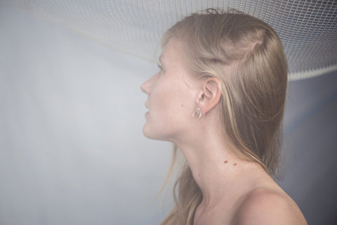 2. Side profile of woman wearing Maarja Palu LAYERS x1 silver earrings, highlighting versatility