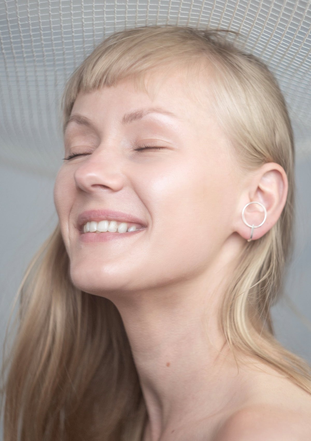 1. Woman wearing Maarja Palu LAYERS x1 silver earrings, showcasing minimalist design