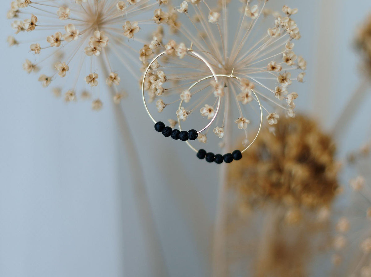 1. 14K gold plated diffuser earrings with black lava beads by Canary Lava, displayed with dried flowers