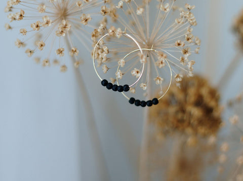 1. 14K gold plated diffuser earrings with black lava beads by Canary Lava, displayed with dried flowers