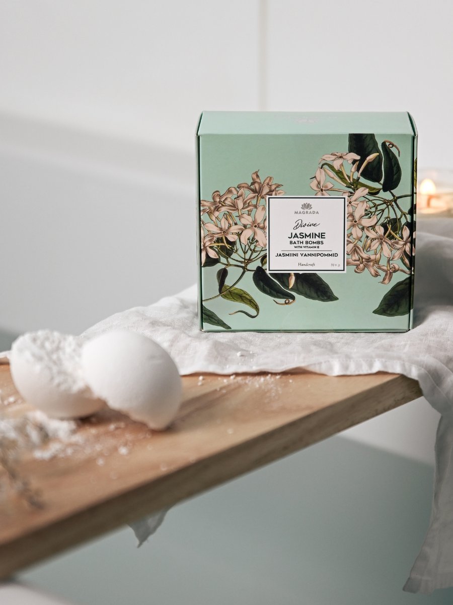 1. Lifestyle image of Magrada Organic Cosmetics Divine Jasmine Bath Bomb set with box and bath bomb on wooden board near bathtub