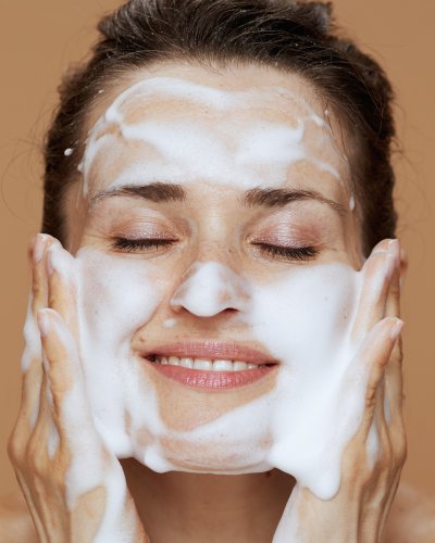 2. Nurme Gentle Neroli Cleansing Foam bottle held in hand, dispensing foam, highlighting product use