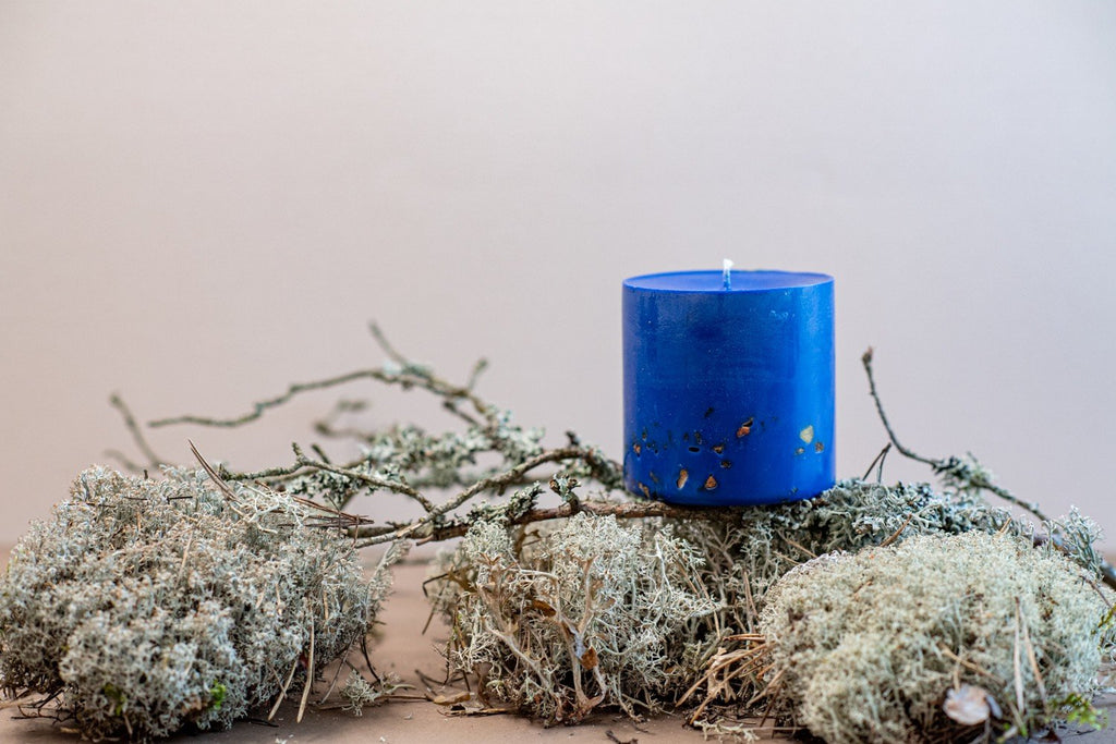 8. TL Candles hand-made blue soy wax candle with amber pieces, displayed on natural moss and branches