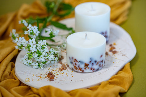 1. Hand-made soy wax candles with amber pieces on decorative plate, surrounded by flowers, showcasing pine scent by TL Candles