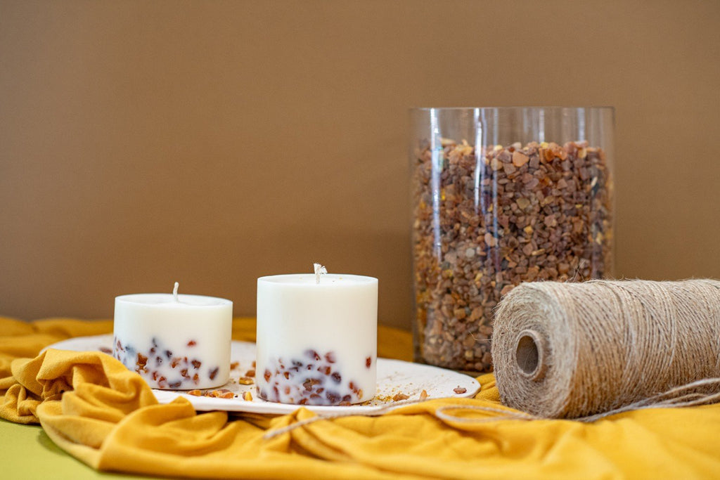 3. Studio shot of TL Candles soy wax candles with amber pieces, displayed with twine and decorative elements