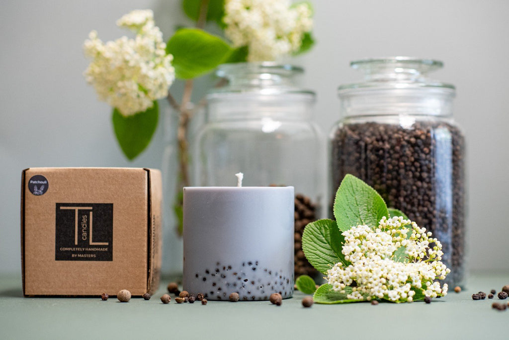 2. TL Candles hand-made soy wax candle with patchouli scent, shown with packaging and natural elements