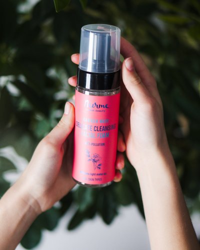 1. Woman holding Nurme Rose Face Cleansing Foam in a natural setting, highlighting eco-friendly packaging